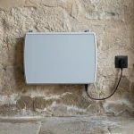 Dispositivo ATE installato su parete in pietra con evidenti segni di umidità